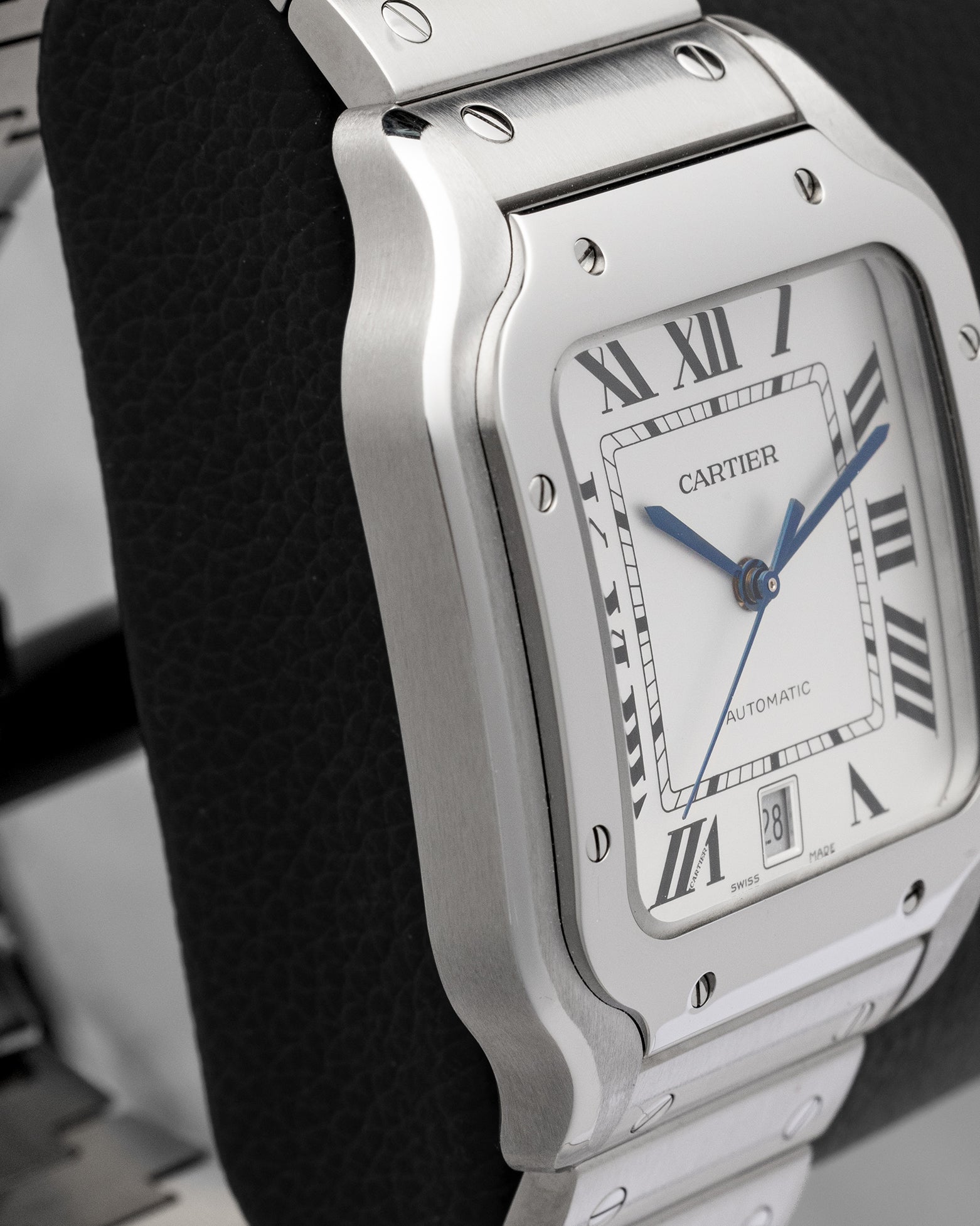 Left side profile view displaying the ergonomic curved stainless steel case and bezel screws of Cartier Santos de Cartier WSSA0018