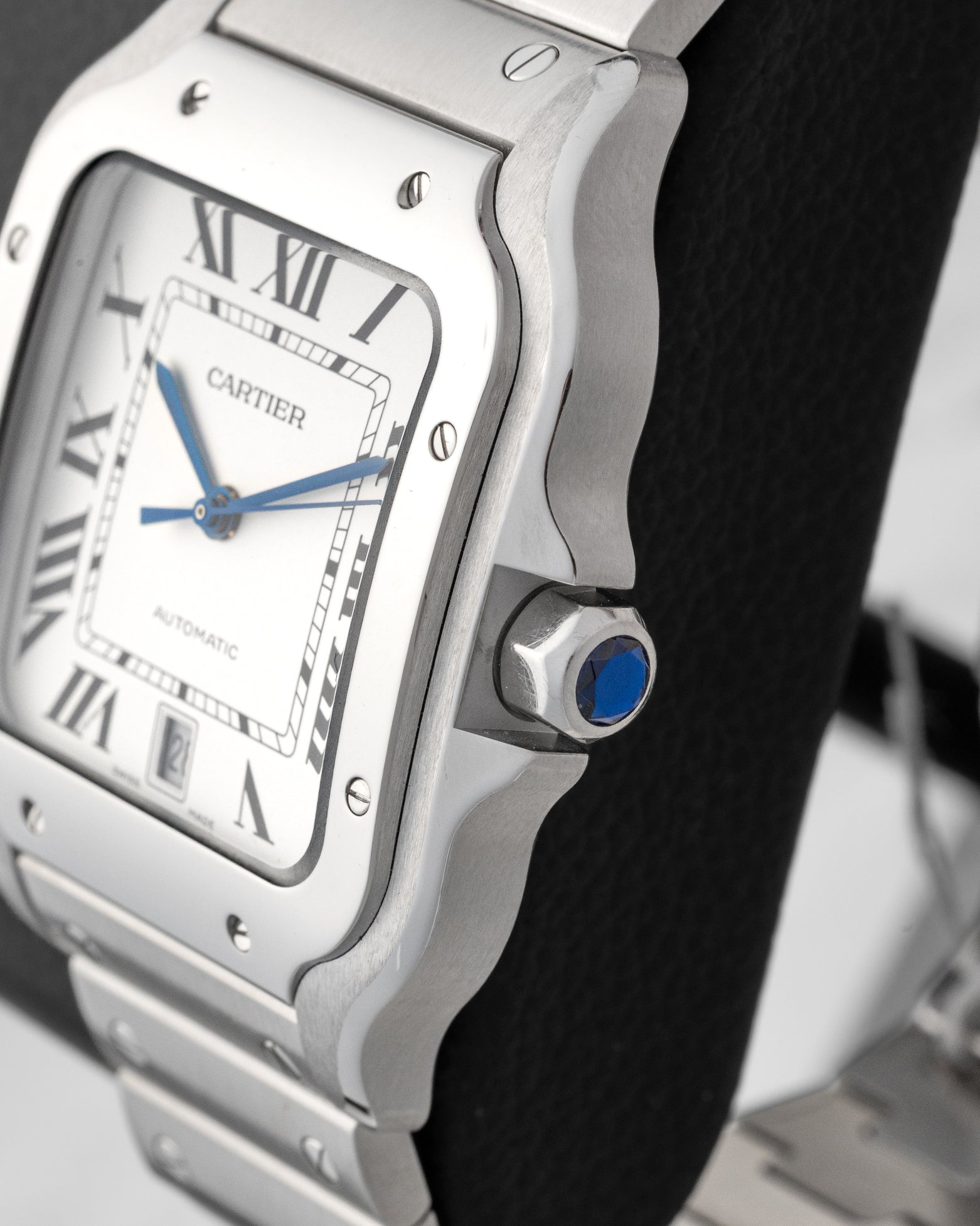 Side profile view showing the seven-sided crown set with a faceted blue synthetic spinel and stainless steel case on Cartier Santos WSSA0018