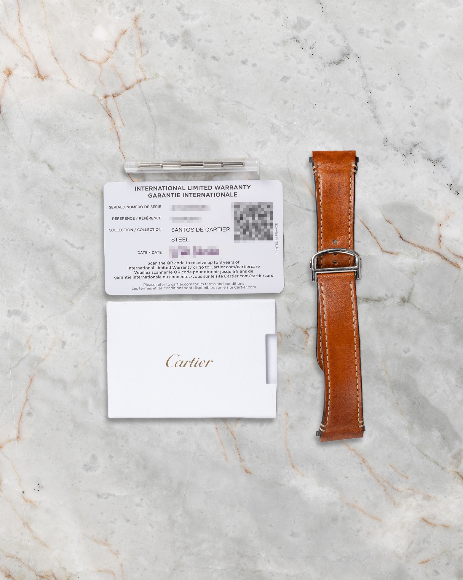 Additional tan calfskin leather strap with QuickSwitch system and original Cartier warranty paper included with Santos WSSA0018 set