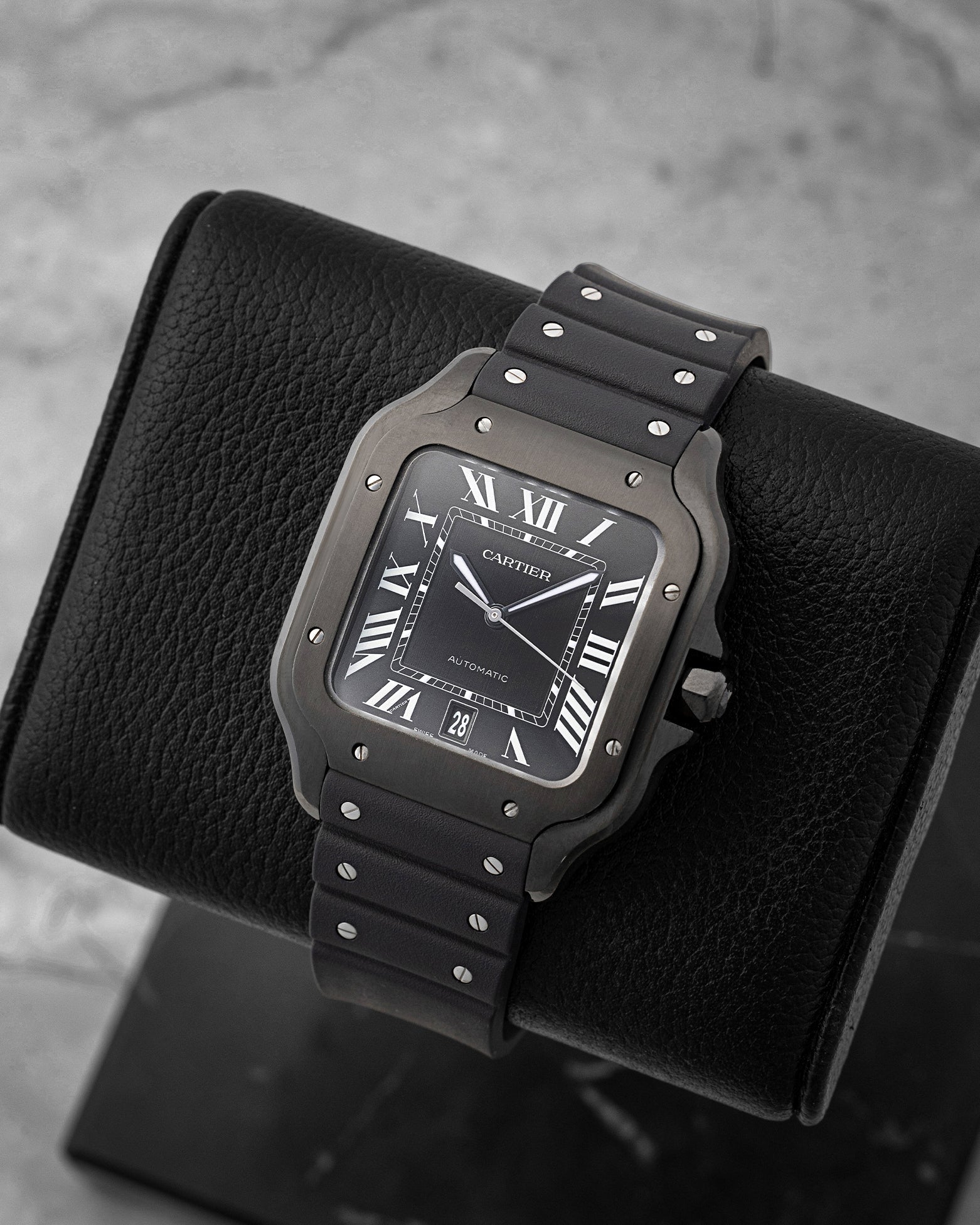 Angled view of pre-owned Cartier Santos de Cartier WSSA0039 featuring a black ADLC case, black dial, and luminous sword hands