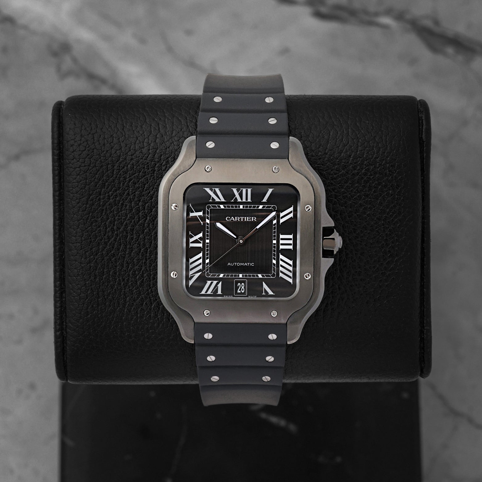 Front view of a pre-owned Cartier Santos de Cartier Large Model Ref WSSA0039 featuring a steel case, black ADLC bezel, and matching black dial, available at Noah's Fine Watches and Jewelry Dallas