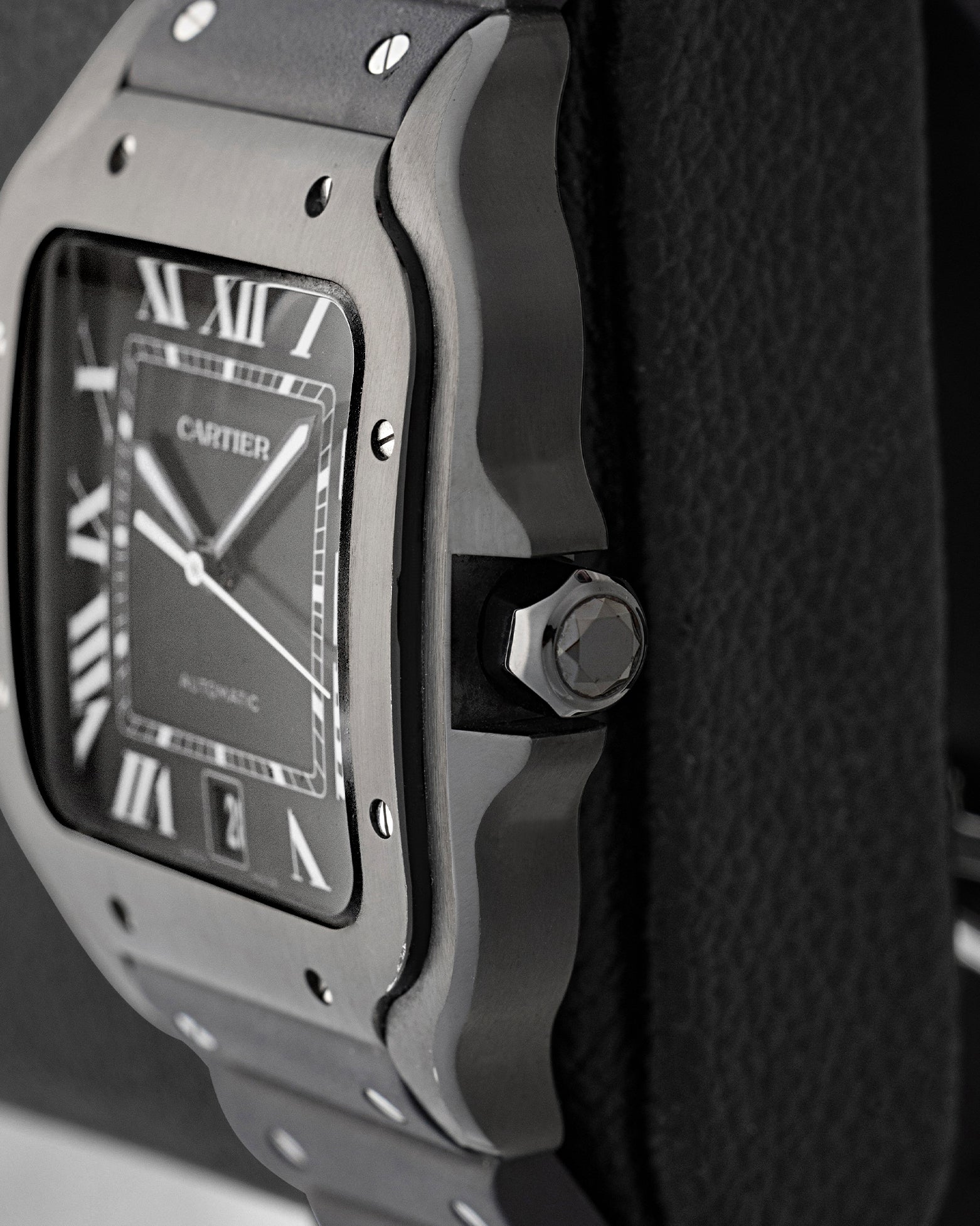 Side profile view showing the black synthetic spinel-set crown and black ADLC stainless steel case of Cartier Santos WSSA0039