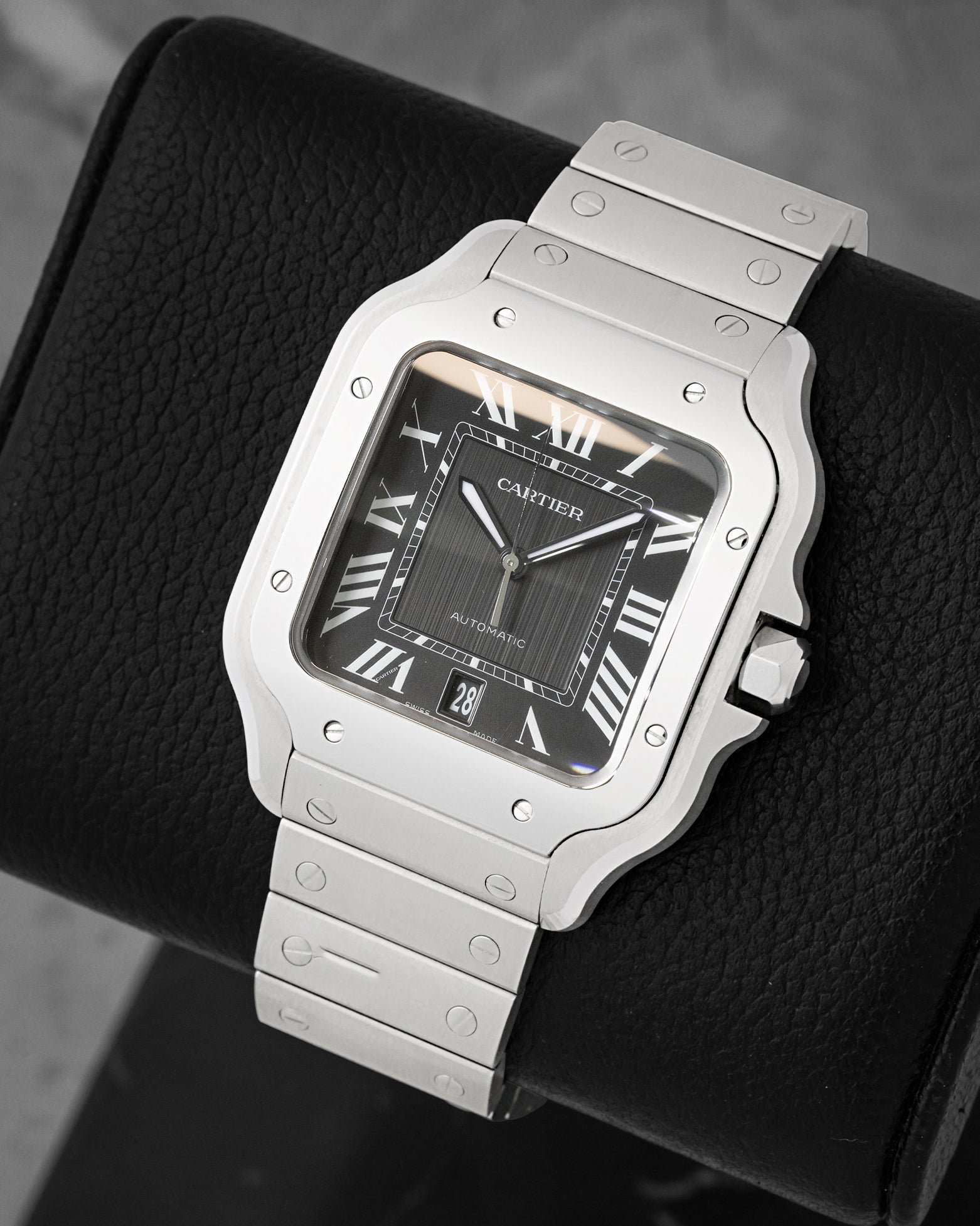 front view of Cartier Santos WSSA0096 highlighting the black dial, luminous Roman numerals, and steel bracelet