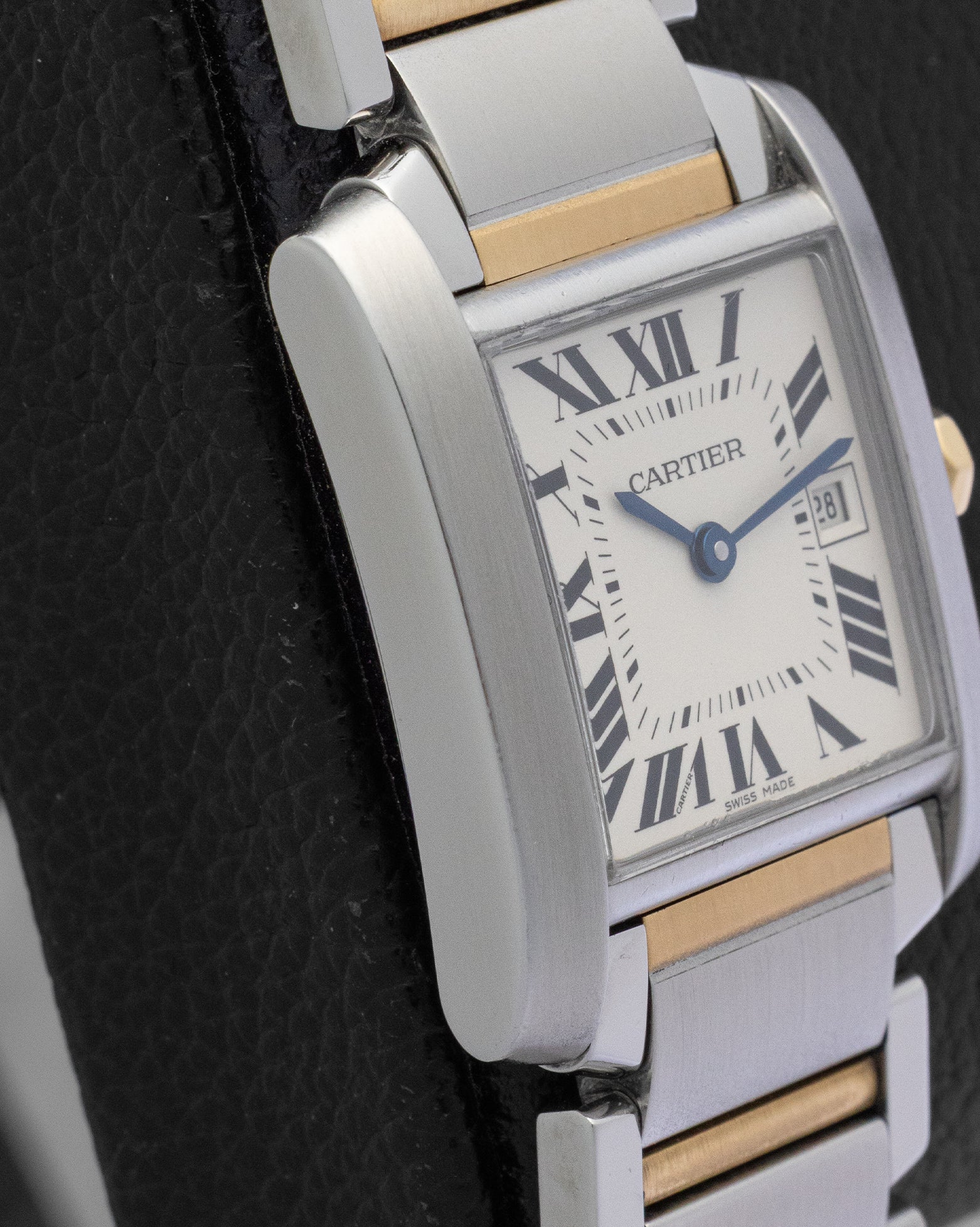 Left side view of the iconic rectangular case and vertically satin-brushed steel brancards on a midsize Cartier Tank watch