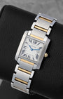 Angled view of a two-tone Cartier Tank Française watch with a date window and blued-steel sword hands