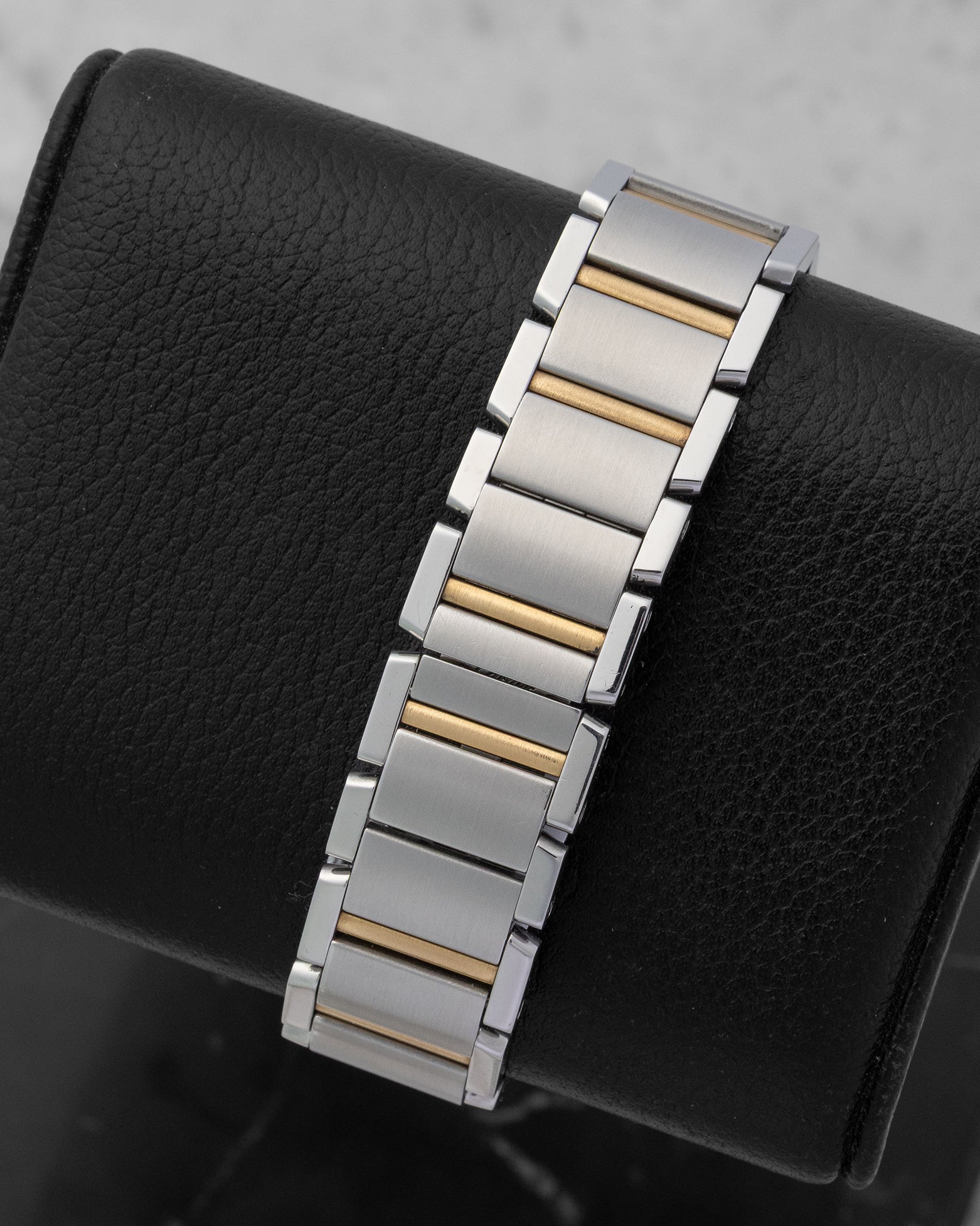 integrated two-tone watch link bracelet on a Cartier Tank Française showing the 18k yellow gold center links