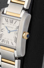 Right side profile close-up of a Cartier Tank Française case showing the octagonal 18k yellow gold crown set with a blue cabochon spinel