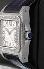 Right side profile of a diamond-encrusted Cartier Santos watch highlighting the faceted crown set with a blue synthetic spinel