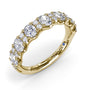Angled side view of the Fana W6655 yellow gold diamond anniversary band showing the shared prong settings and high-polish finish
