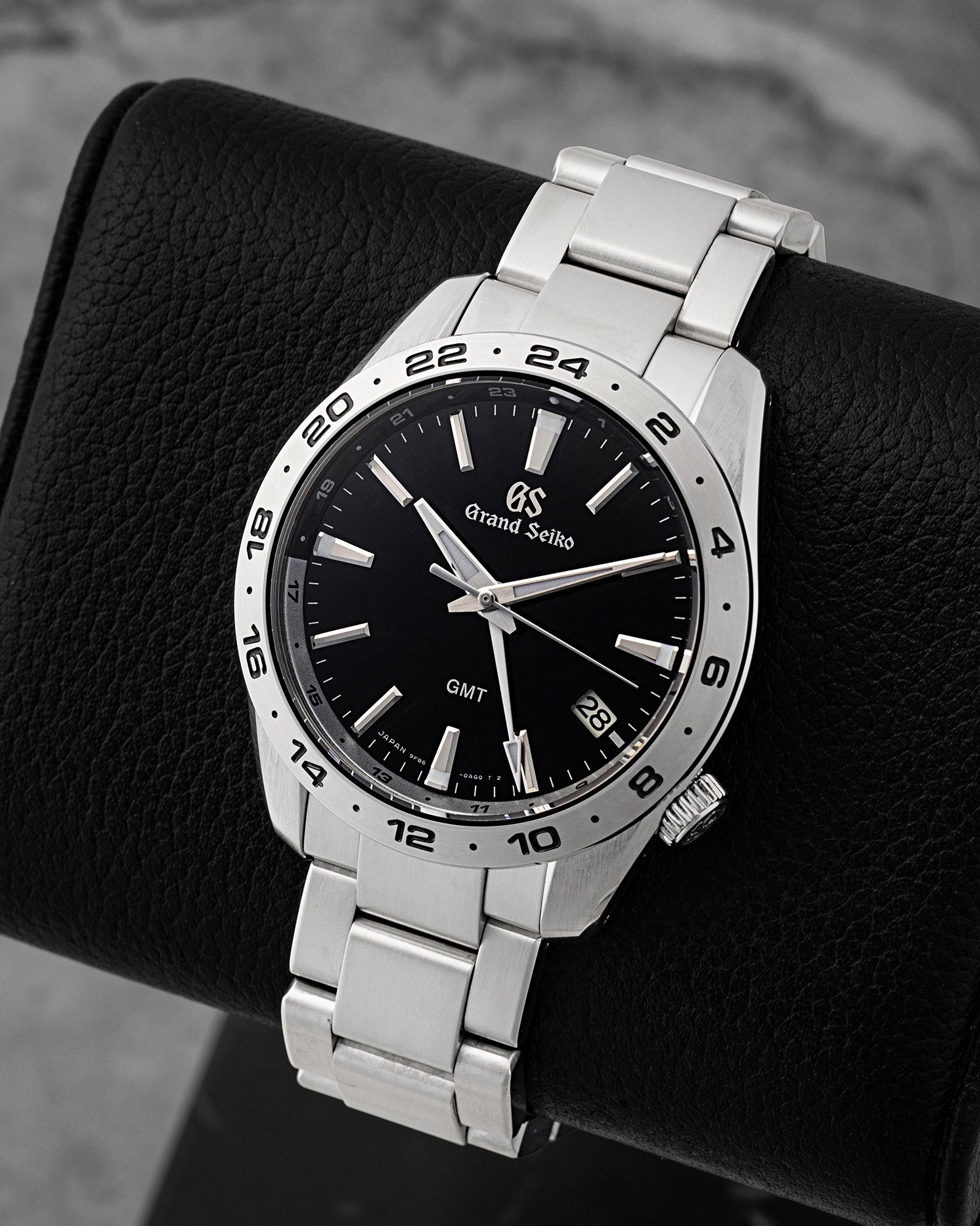 Angled view of pre-owned Grand Seiko Sport GMT SBGN027G featuring a monochrome black dial, white GMT hand, Zaratsu-polished hands, and fixed 24-hour bezel.