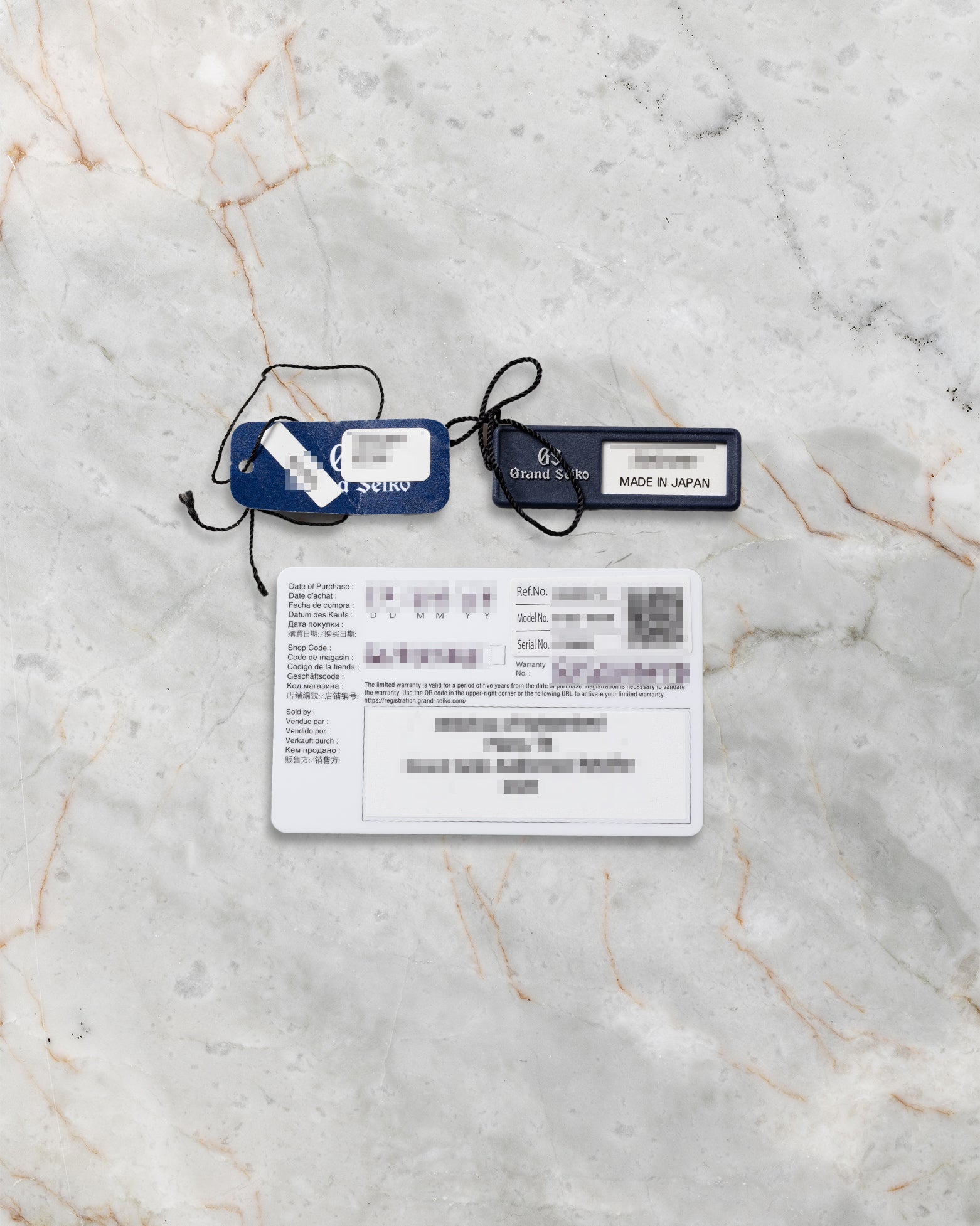 Original Grand Seiko international warranty card and factory serial hangtags included with pre-owned SBGN027G
