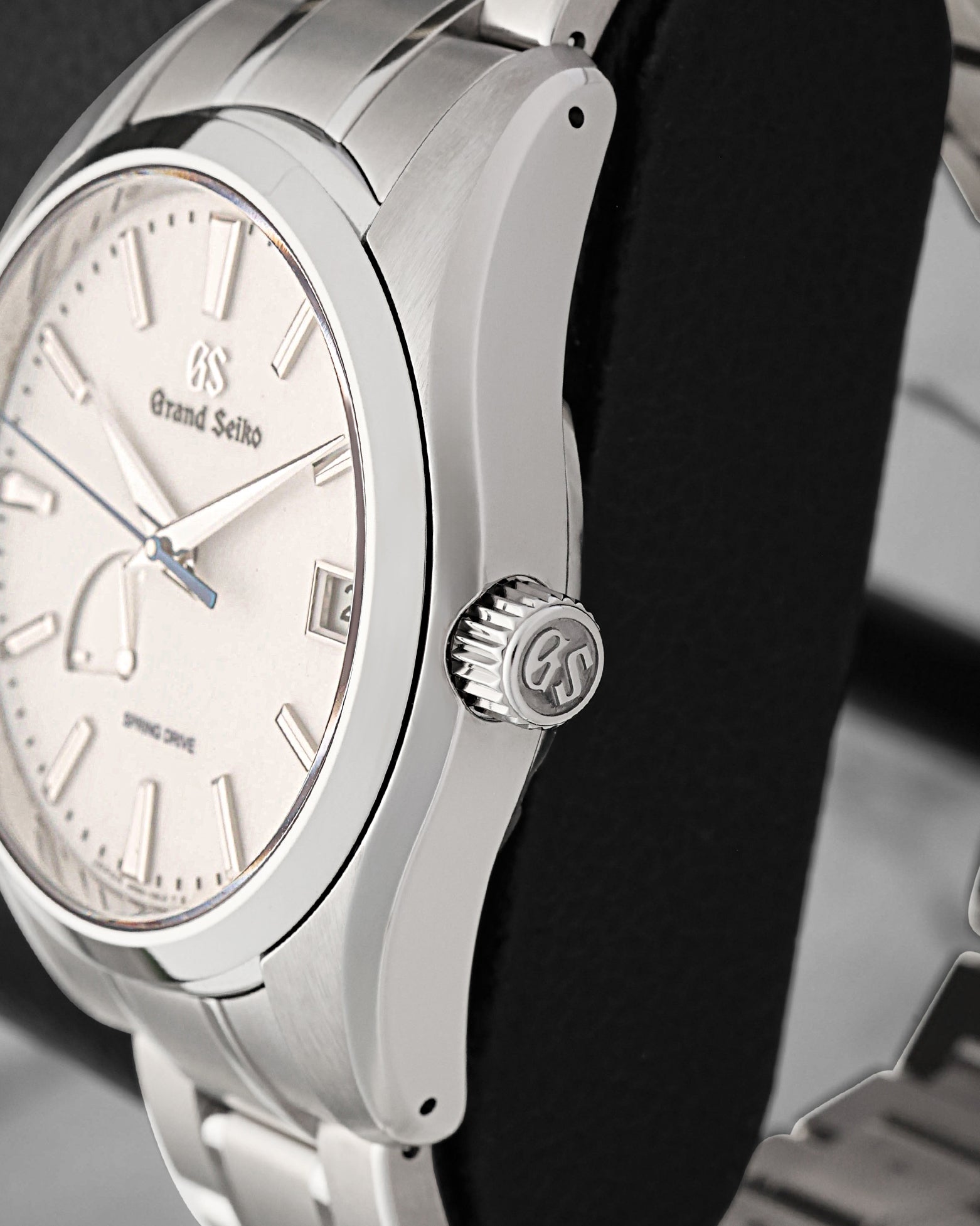 Close-up right profile view of the watch head highlighting the push-pull crown engraved with the GS logo and the distortion-free Zaratsu mirror polishing along the titanium bezel