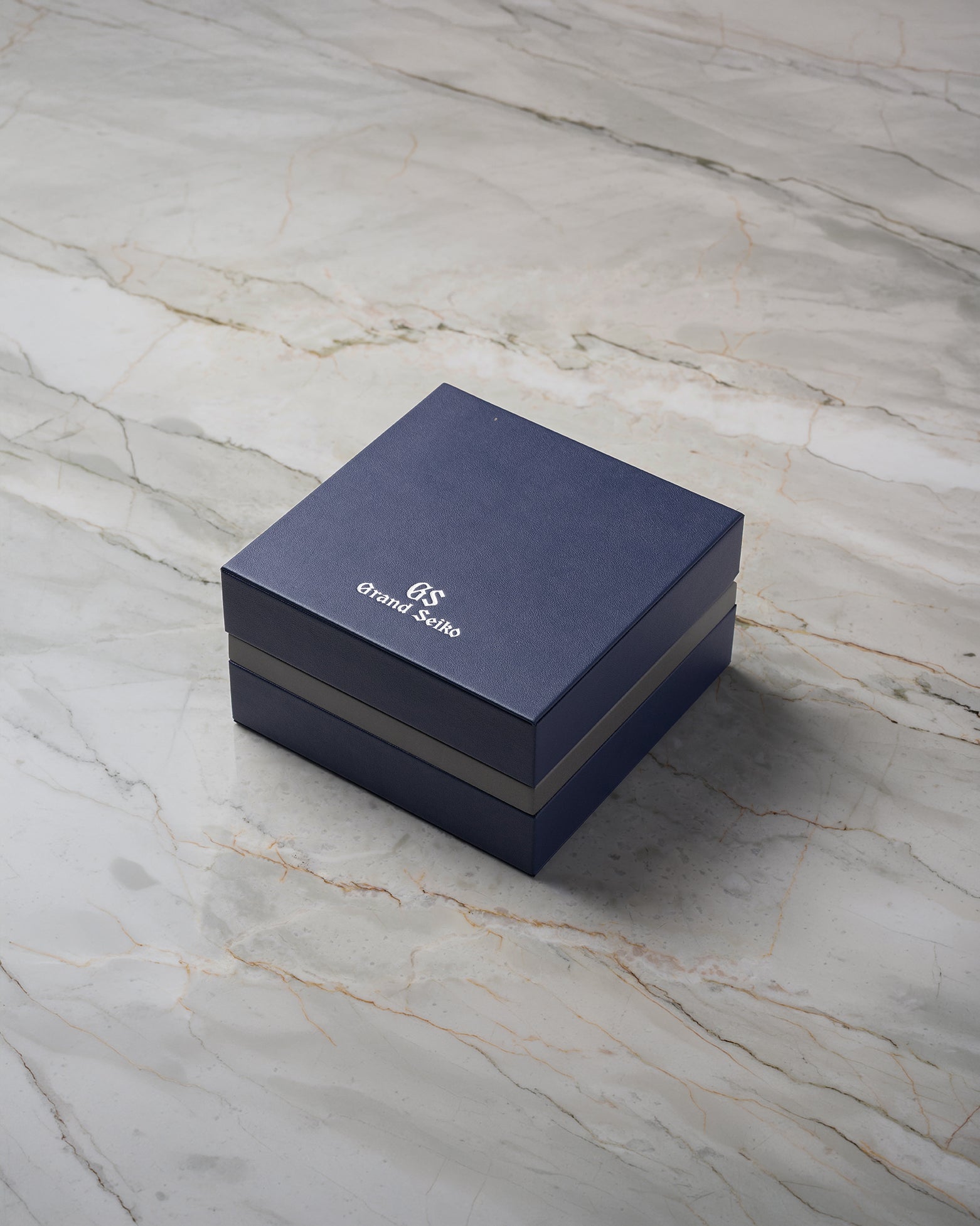 Official navy blue Grand Seiko presentation watch box included with pre-owned Sport GMT SBGN027G at Noah's Fine Watches & Jewelry in Dallas