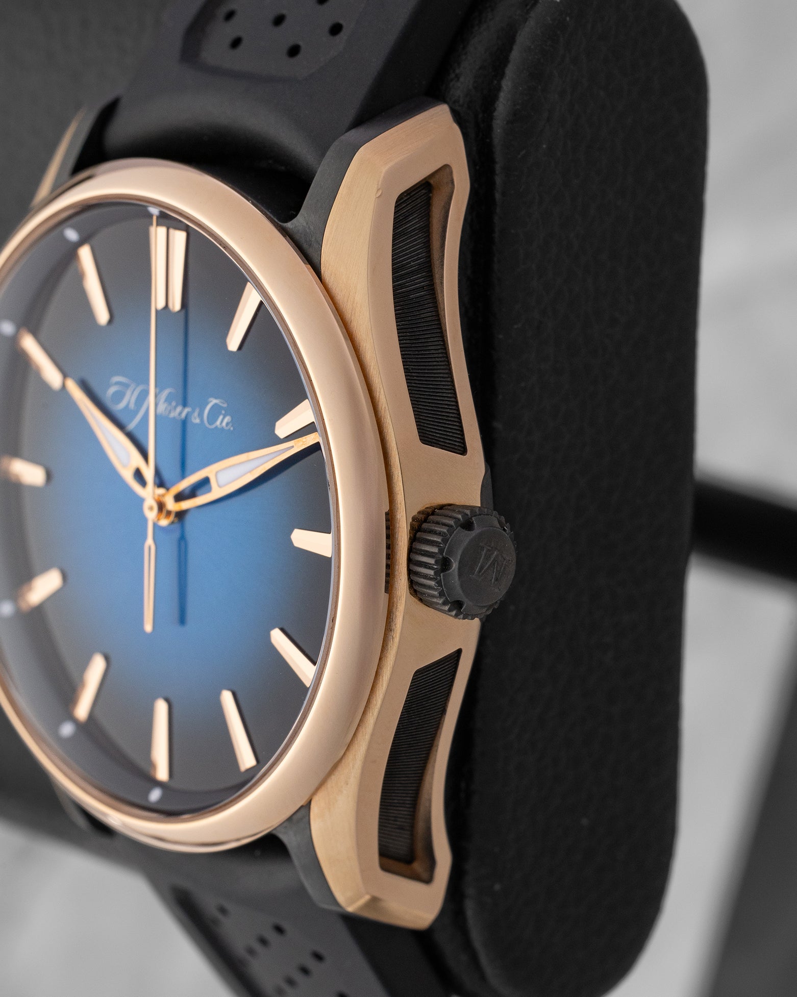 close-up side profile view of the H. Moser Pioneer case highlighting the architectural black DLC-coated titanium side inserts and crown
