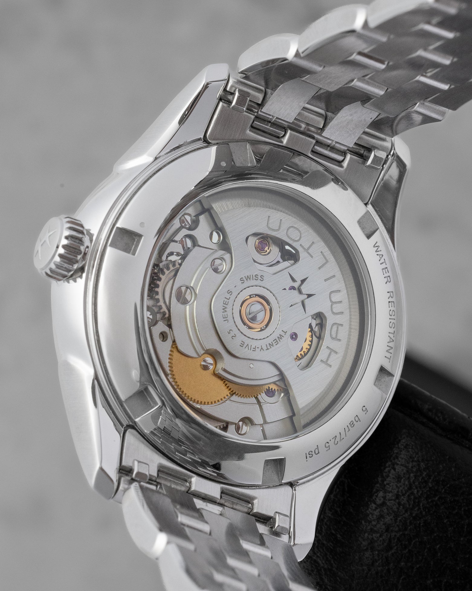 The clear sapphire crystal caseback of a Hamilton watch revealing the skeletonized automatic movement rotor inside