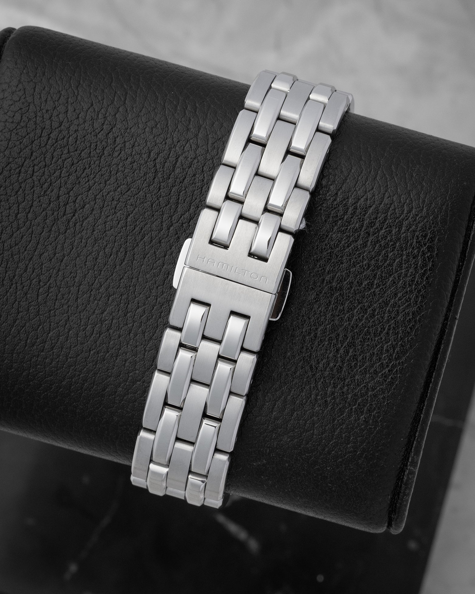 Engraved Hamilton branding on the folding deployment clasp of a stainless steel watch link bracelet