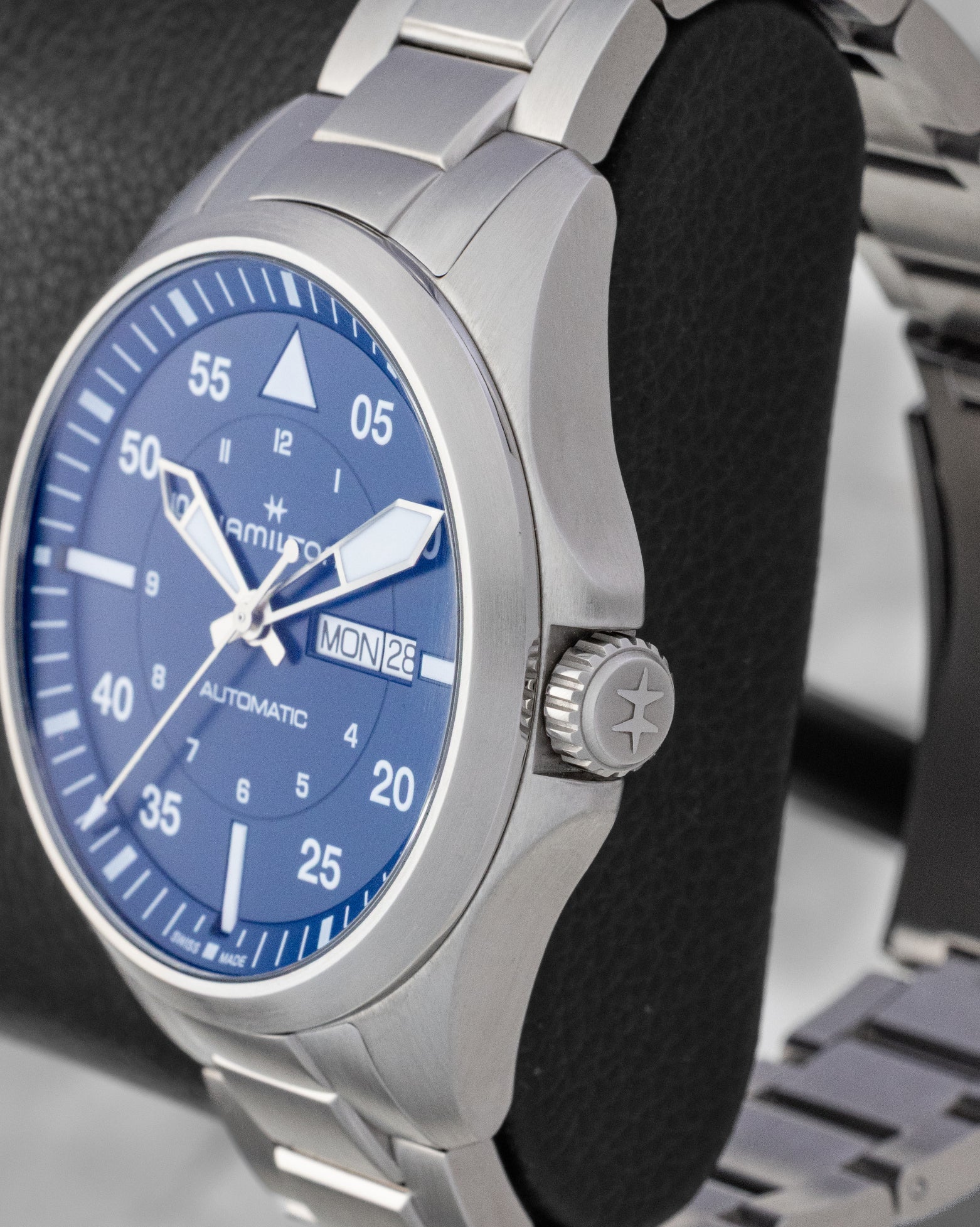 Close-up profile view of the brushed stainless steel case and crown guard on a Hamilton aviation watch