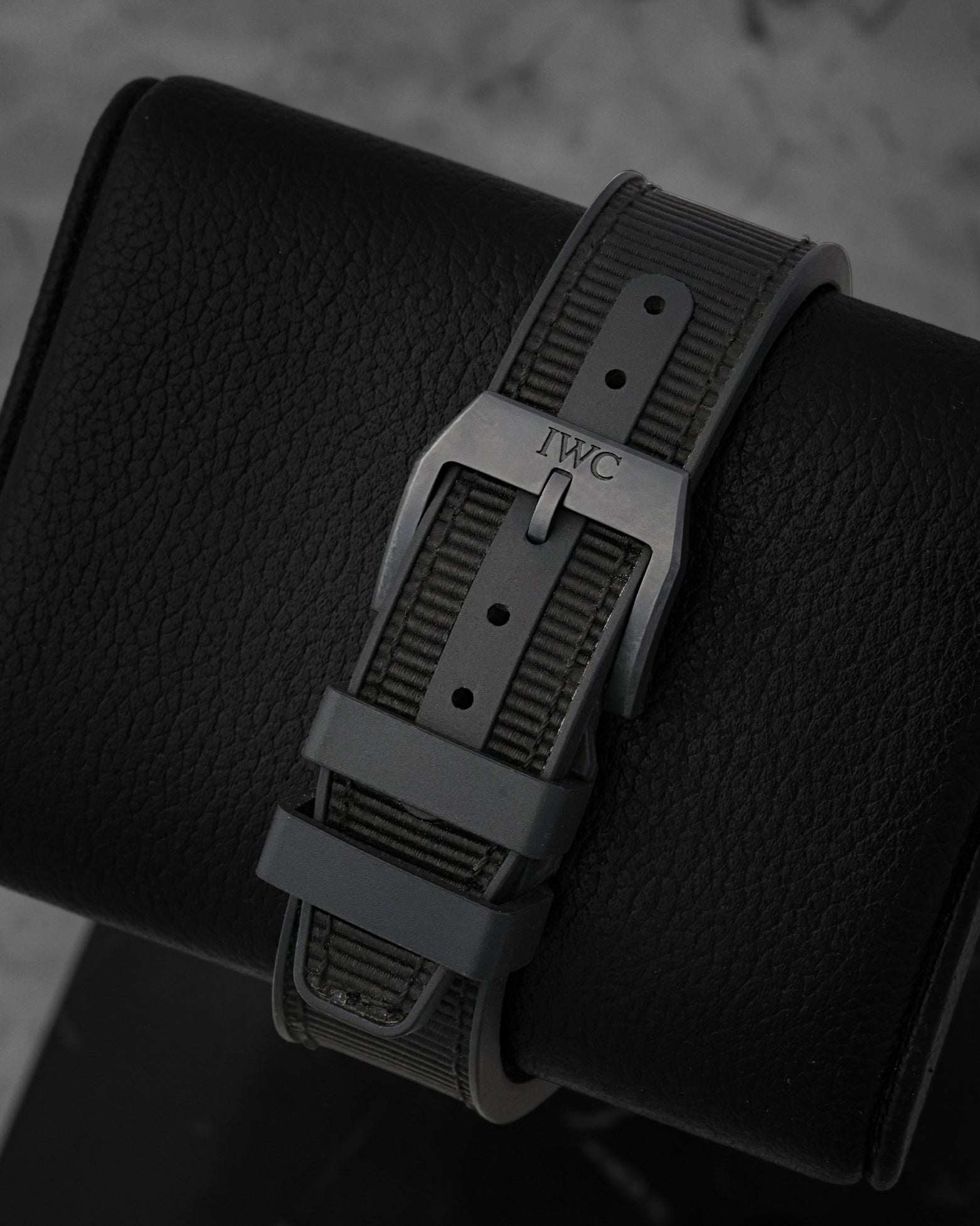 Rear perspective of the black rubber strap with textile inlay, secured by a matching matte black Ceratanium pin tang buckle