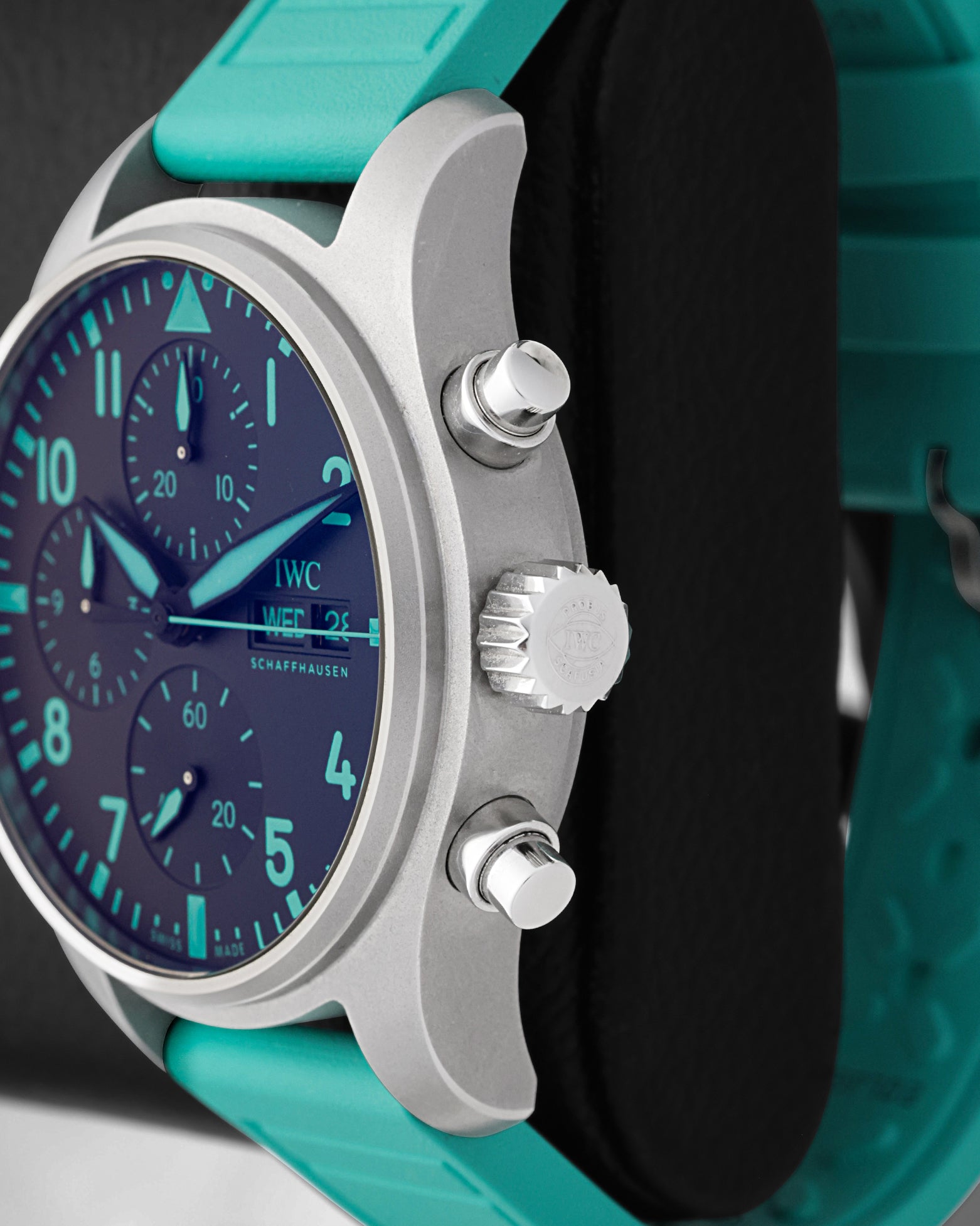 Side profile view of the sandblasted titanium case showing the fluted crown and twin ergonomic piston chronograph pushers