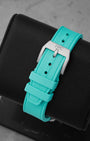 Rear studio view of the textured Petronas green rubber watch strap and the matching sandblasted titanium tang buckle
