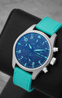 An angled studio profile shot of the lightweight Grade 5 titanium case and vibrant green rubber strap of an IWC F1 Team chronograph