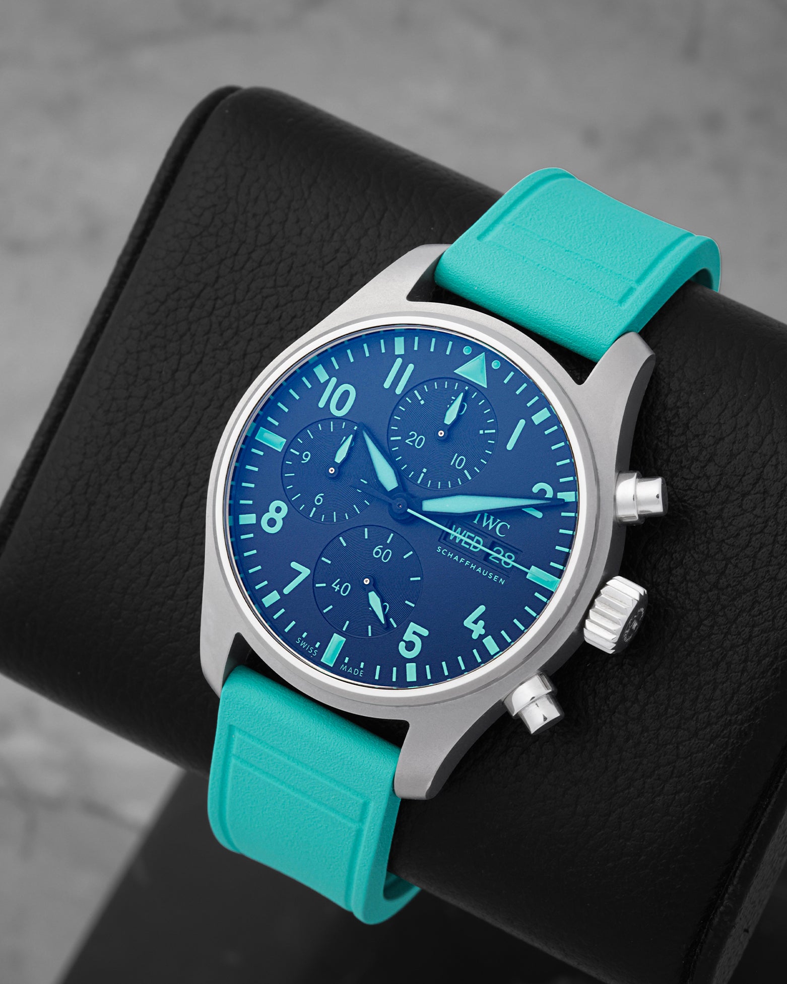 An angled studio profile shot of the lightweight Grade 5 titanium case and vibrant green rubber strap of an IWC F1 Team chronograph