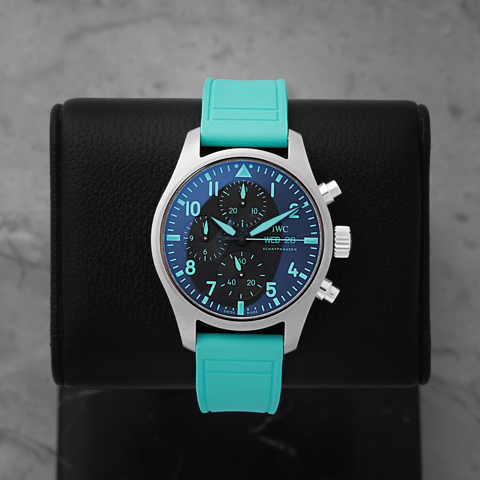 IWC Pilot's Watch Chronograph 41 Mercedes-AMG PETRONAS F1 Team IW388108 titanium watch with a signature green rubber strap on a display stand
