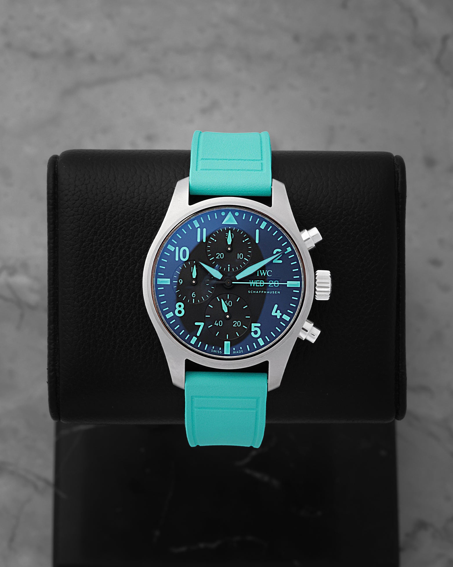 IWC Pilot's Watch Chronograph 41 Mercedes-AMG PETRONAS F1 Team IW388108 titanium watch with a signature green rubber strap on a display stand