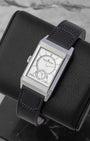 Angled view of a stainless steel Jaeger-LeCoultre Reverso watch on a display stand, highlighting the Art Deco gadroons on the case