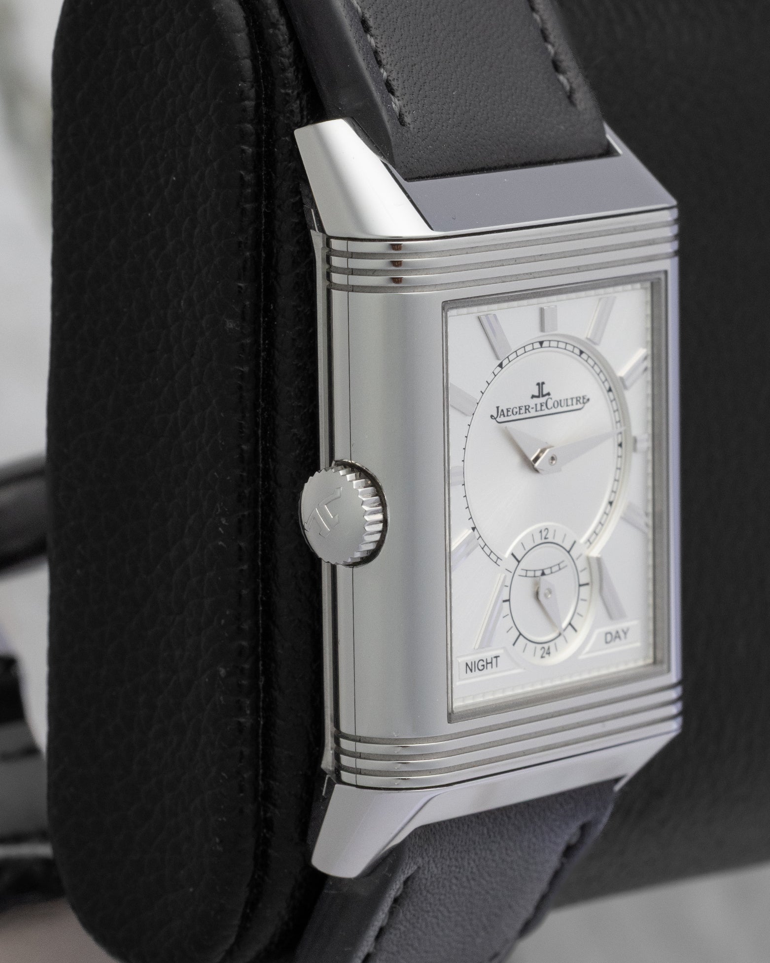 Close-up macro photo of the rectangular stainless steel case crown of a Jaeger-LeCoultre Reverso luxury watch