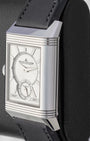 Angled view of a stainless steel Jaeger-LeCoultre Reverso watch on a display stand, highlighting the Art Deco gadroons on the case