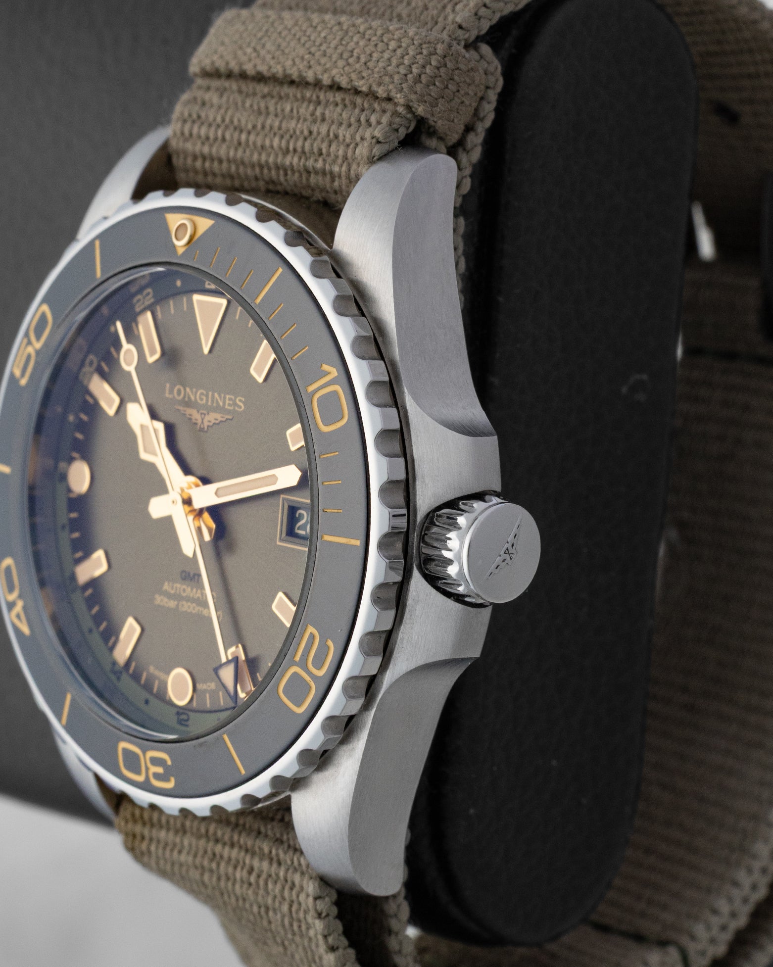 Side view highlighting the screw-down crown, crown guards, and ceramic bezel of the green Longines HydroConquest GMT