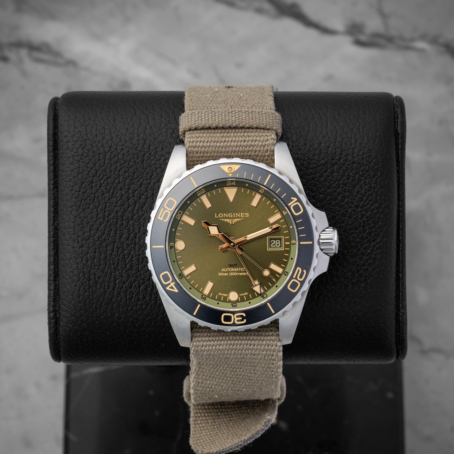 Green dial Longines HydroConquest GMT 41mm watch, model L3.790.4.06.2, on a khaki green fabric strap at Noah's Fine Watches & Jewelry in Dallas