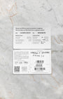 A top-down flat lay view of the official 2026 printed international warranty smart card resting alongside the factory matching barcode reference tag over a grey marble surface