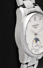 Left-side macro profile view showcasing the mirror-polished curved case flank and the ergonomic integration into the elegant H-link stainless steel dress bracelet