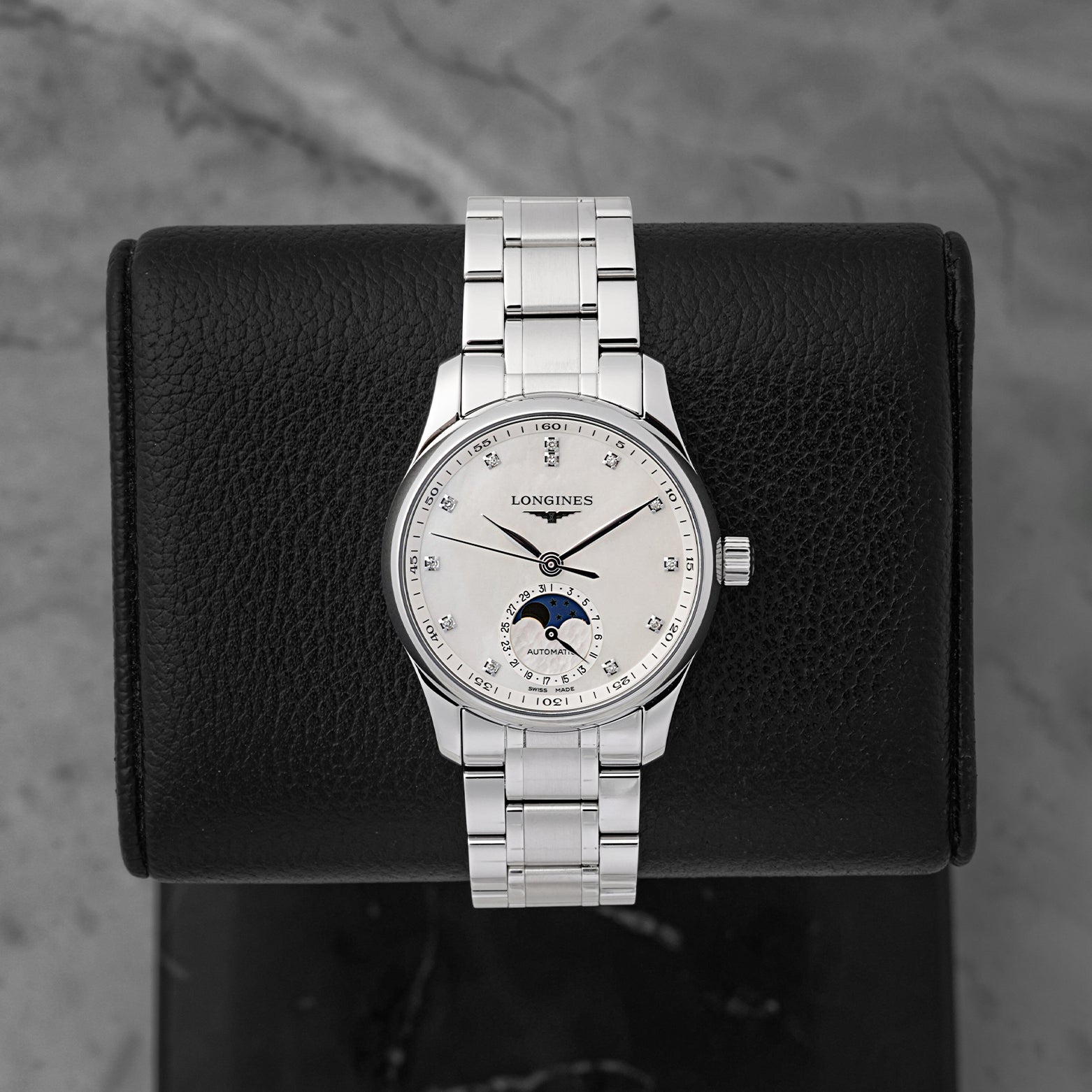 A 2026 Longines Master Collection Moonphase 34mm reference L2.409.4.87.6 showcasing its white mother-of-pearl dial, brilliant-cut diamond hour markers, and midnight blue moonphase indicator at Noah's Fine Watches & Jewelry in Dallas