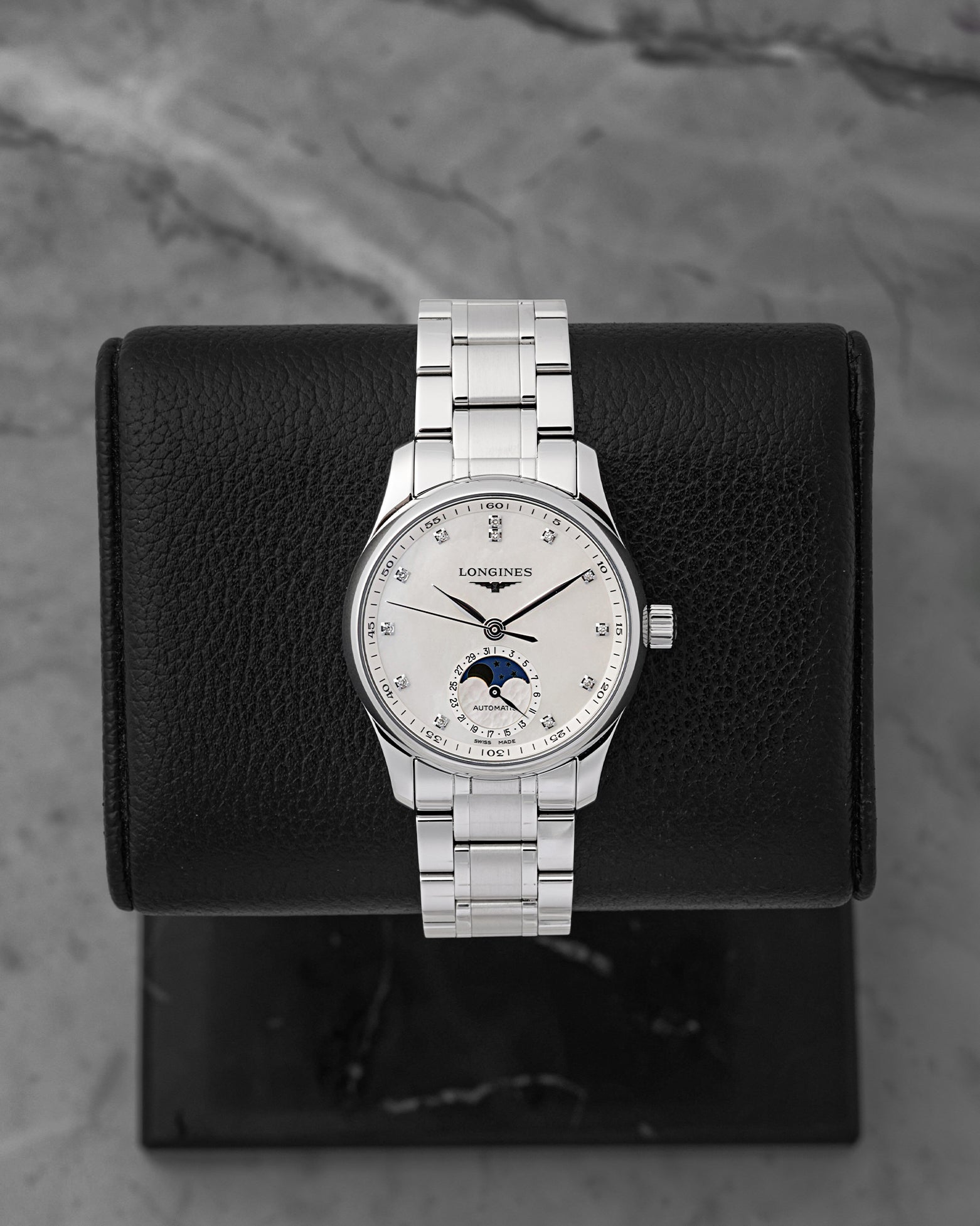 A 2026 Longines Master Collection Moonphase 34mm reference L2.409.4.87.6 showcasing its white mother-of-pearl dial, brilliant-cut diamond hour markers, and midnight blue moonphase indicator at Noah's Fine Watches & Jewelry in Dallas