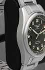 Left-side profile view of the 42mm steel watch chassis showcasing the fine longitudinal satin graining across the case flank and the sharp, mirror-polished bevel lines on the lugs