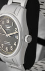Close up right profile view of the watch head highlighting the large vintage-style fluted winding crown embossed with the Longines winged hourglass logo emblem