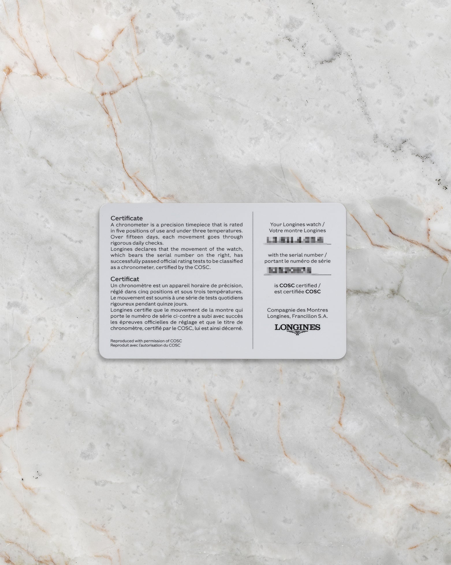 A top-down flat lay view of the official white and grey Longines international guarantee smart card displaying printed model calibration and serial information