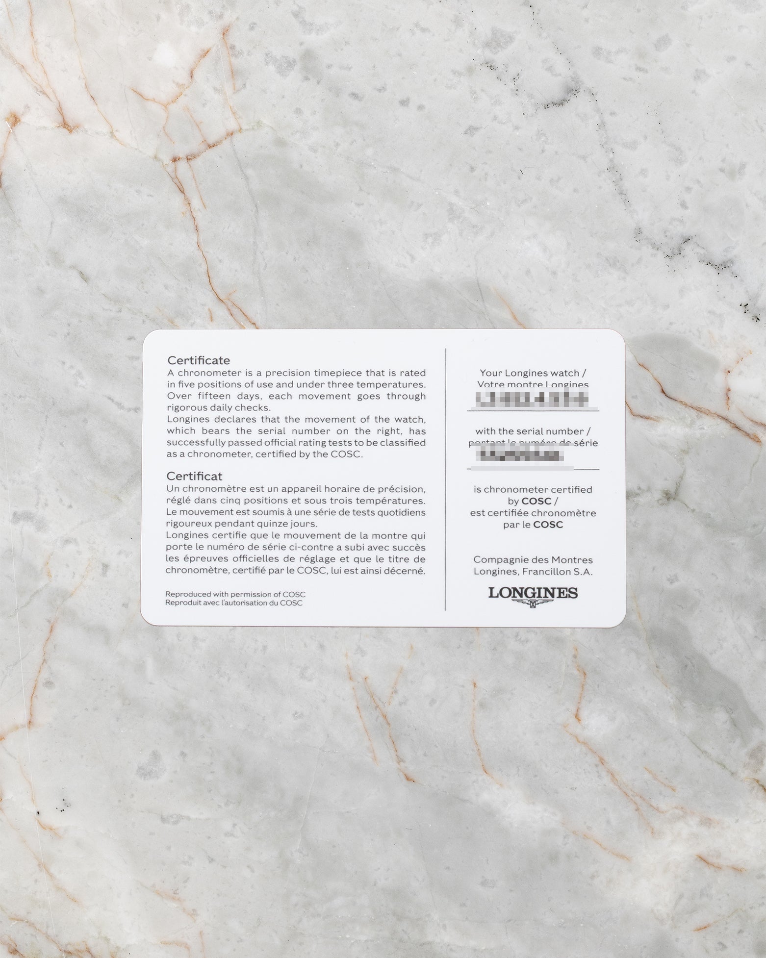 A top-down flat lay view of the official white and grey Longines international guarantee smart card displaying printed model calibration and serial information