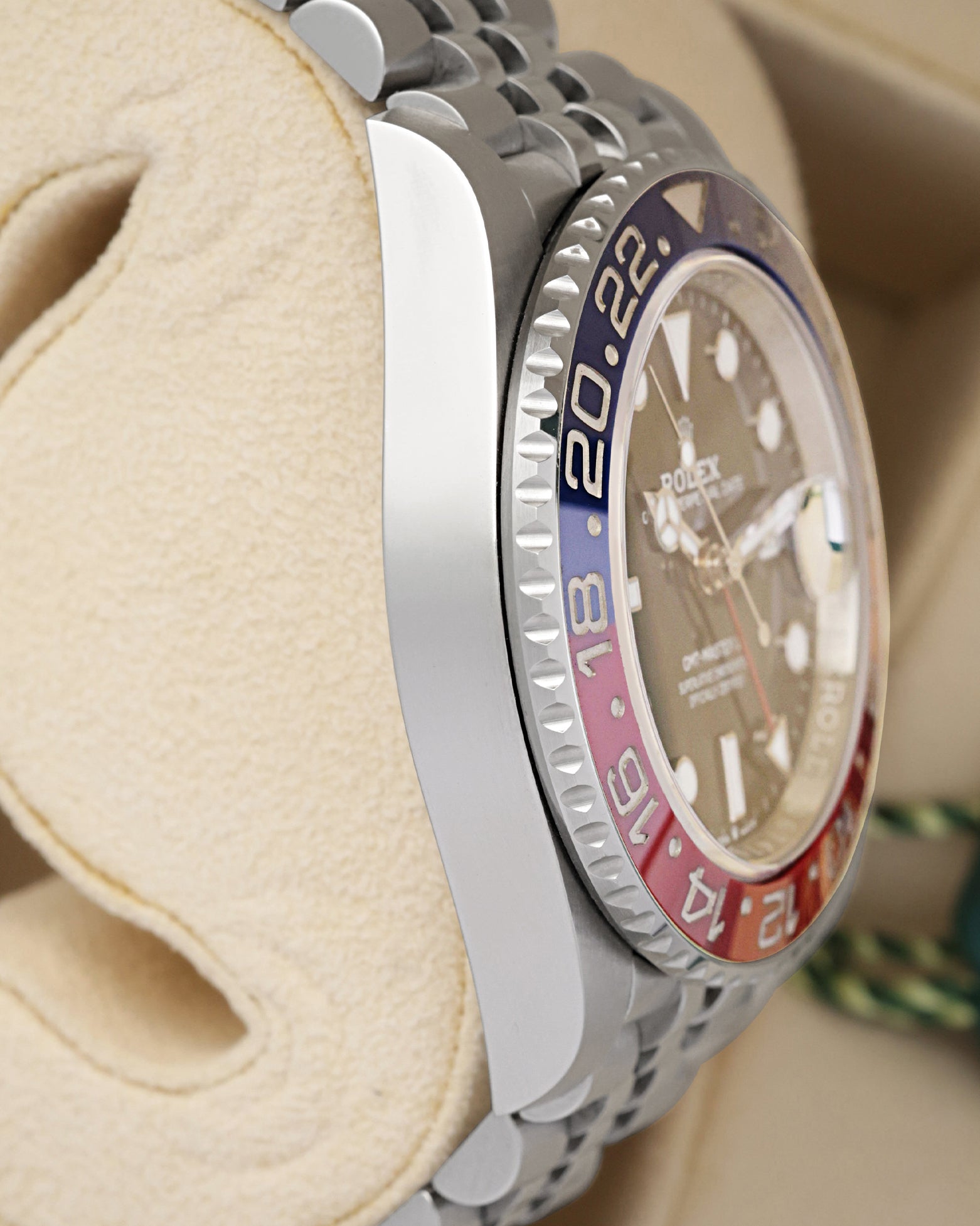 Left side perspective highlighting the bidirectional rotating knurled edge bezel and the high-contrast red and blue Cerachrom ceramic 24-hour insert