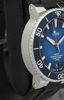 Left side perspective highlighting the brushed case finish, domed sapphire crystal with