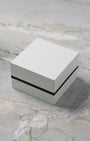 A high-angle three-quarter shot of the official minimalist square grey and black Montblanc watch presentation box resting closed on a marble backdrop