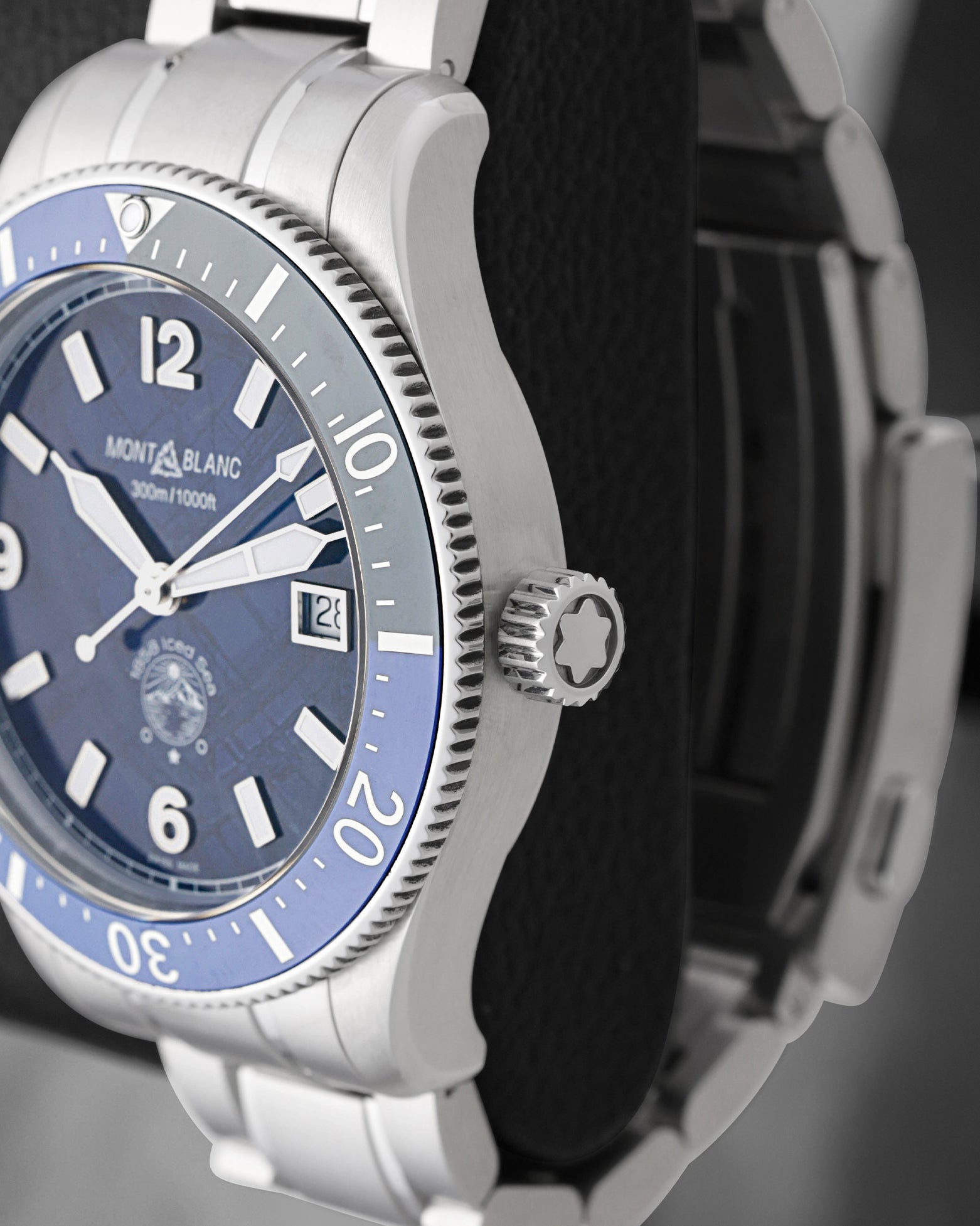 Close-up right profile view of the 1858 Iced Sea watch head focusing on the knurled blue ceramic timing ring and the fluted crown engraved with the iconic white Montblanc star emblem