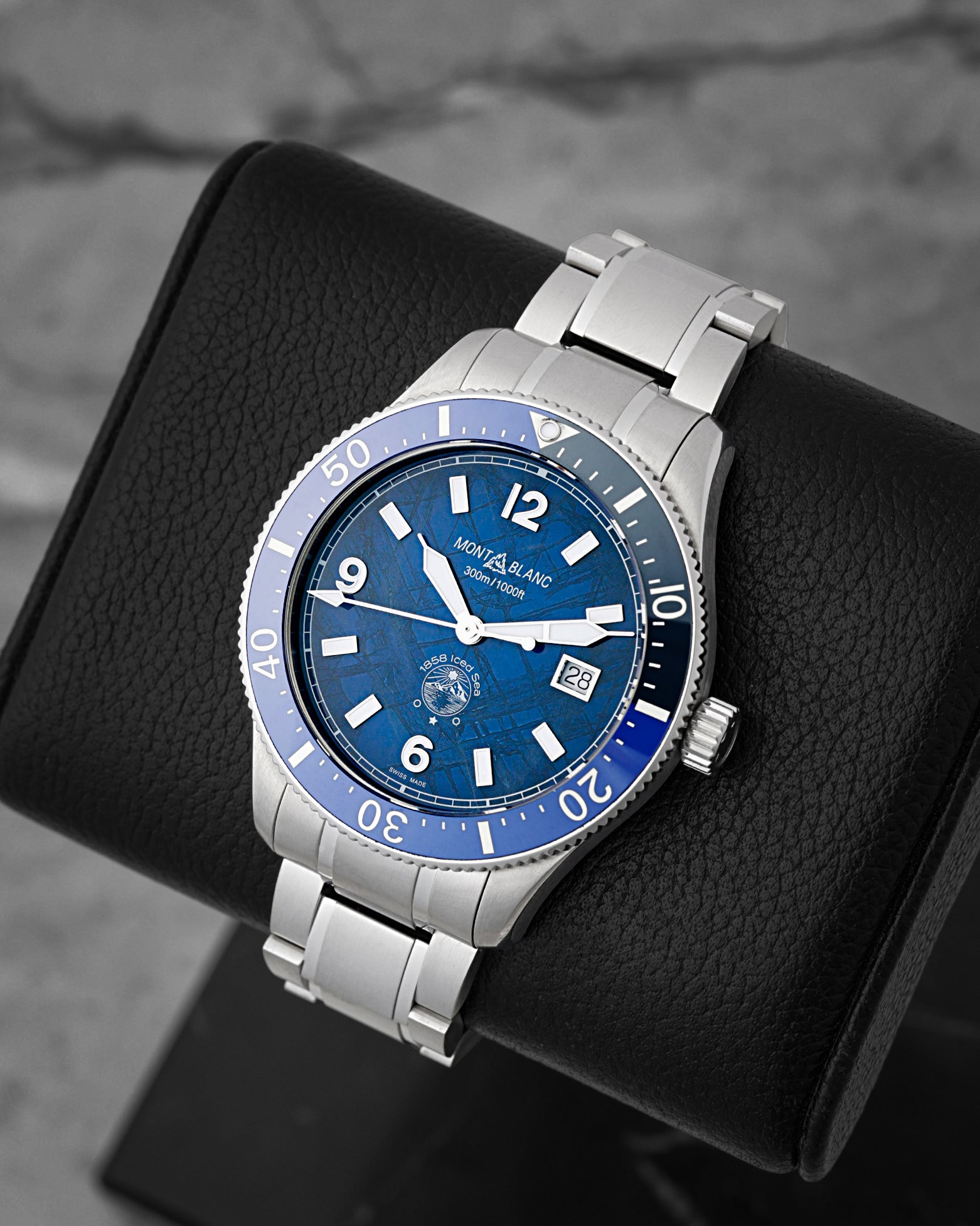 A high-angle three-quarter studio profile of the 41mm stainless steel Montblanc Iced Sea watch case resting on a black leather cushion to highlight its textured dial depth