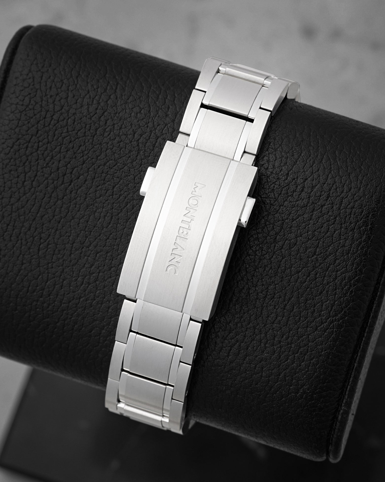 A rear view of the interchangeable three-link stainless steel bracelet focusing on the secure folding deployment clasp engraved with the traditional Montblanc script logo