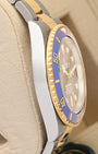 Left side view showcasing the polished Oystersteel case edges and distinct knurled gold bezel profile of the 41mm Rolex Bluesy