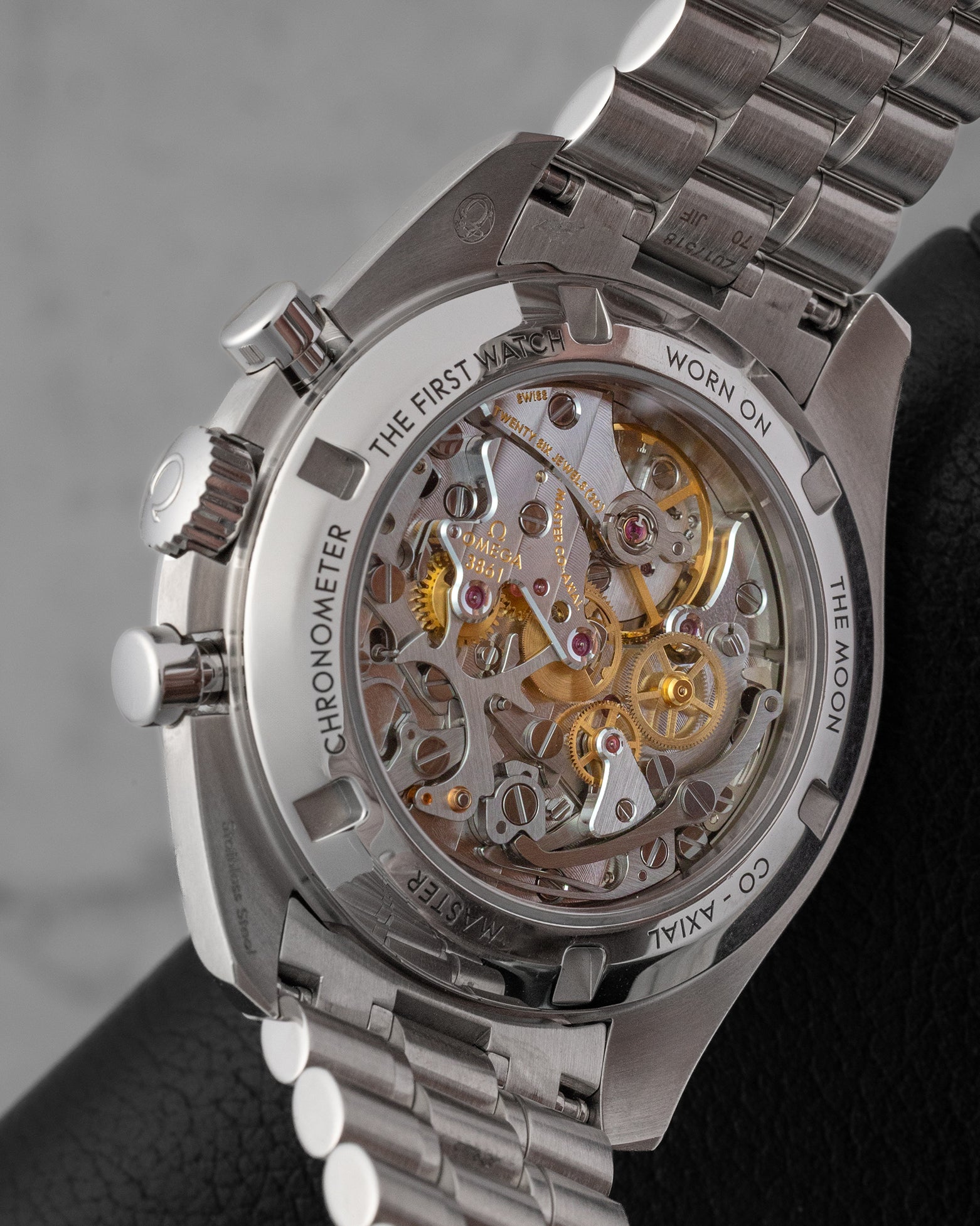 The reverse profile view through a sapphire crystal exhibition caseback revealing the manual-winding Omega Calibre 3861 movement with luxury rhodium-plated finishes