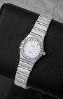 Angled view of the ladies Omega Constellation reference 1465.71.00 26mm showing the mother of pearl dial, iconic claws, and stainless steel integrated bracelet.
